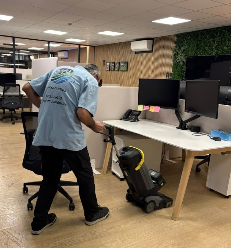 Medewerker van PM Cleaning met compacte schrobmachine in een open space