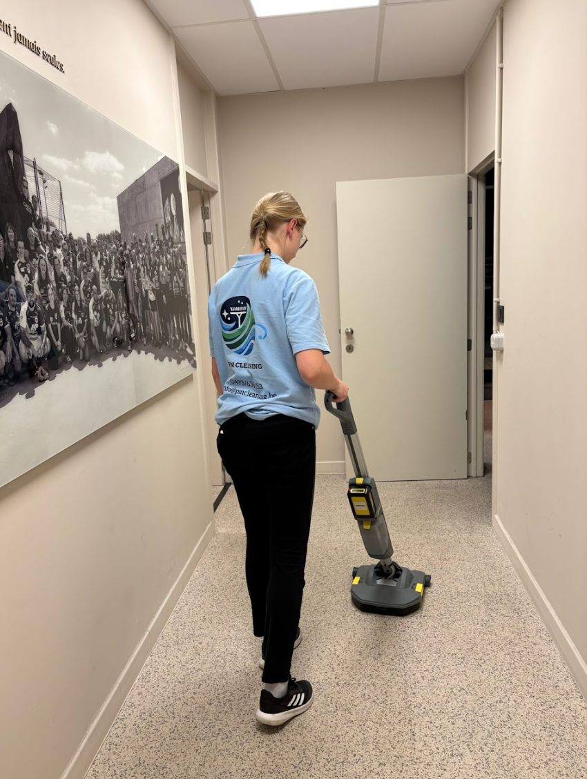 Medewerker van PM Cleaning met eenschijfsmachine in een gang